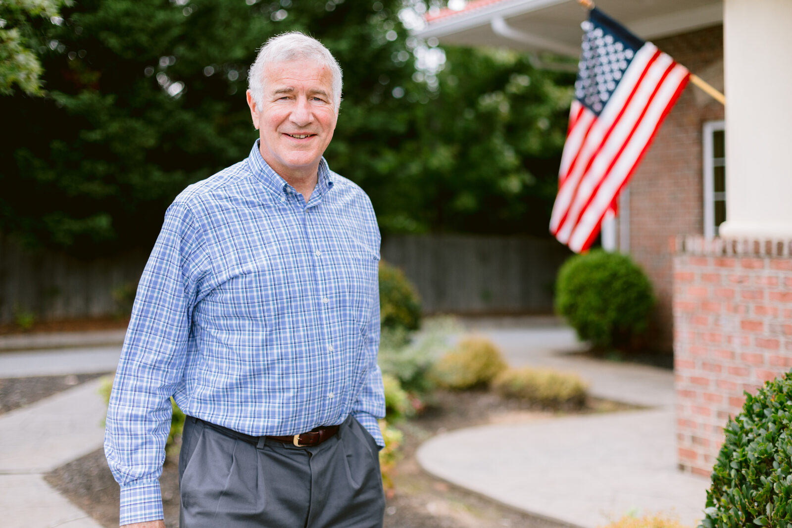 John Blust standing in front of his home
